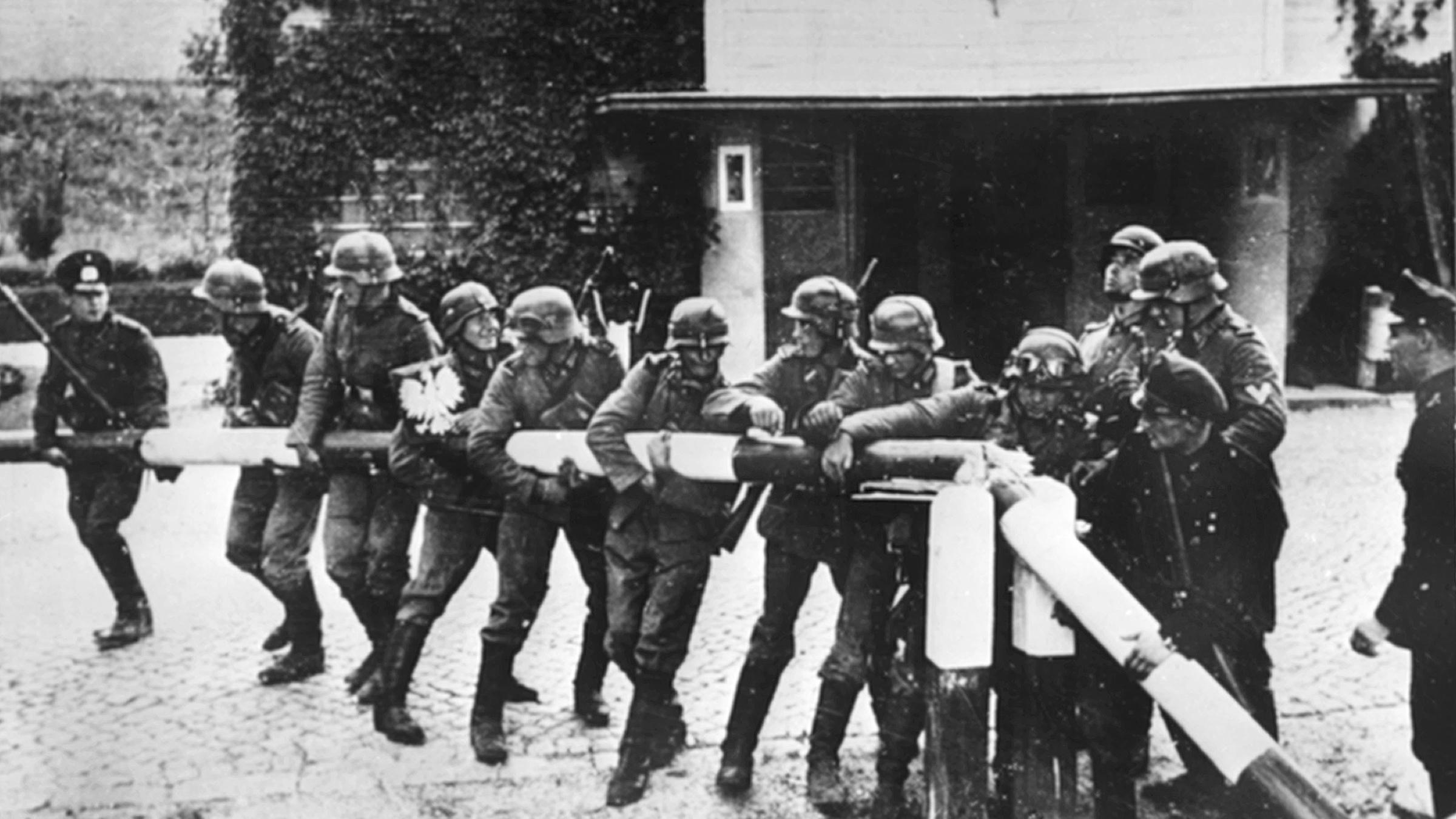 Deutsche Soldaten reißen 1939 einen Schlagbaum an der deutsch-polnischen Grenze nieder