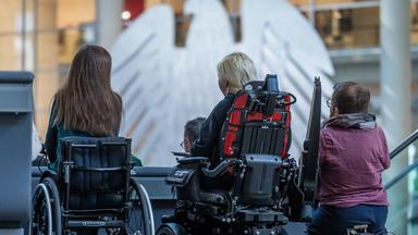 Aktivisten im Rollstuhl verfolgen am 07.05.2026 die Debatte zur Änderung des Behindertengleichstellungsgesetzes im Plenarsaal im Bundestag.