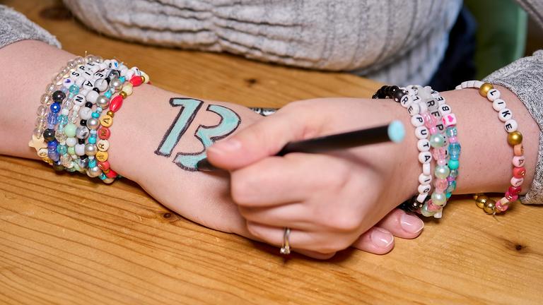 Nahaufnahme beider Hände von Kim Niehaus (26): Sie malt sich gerade eine "13" auf die Hand.