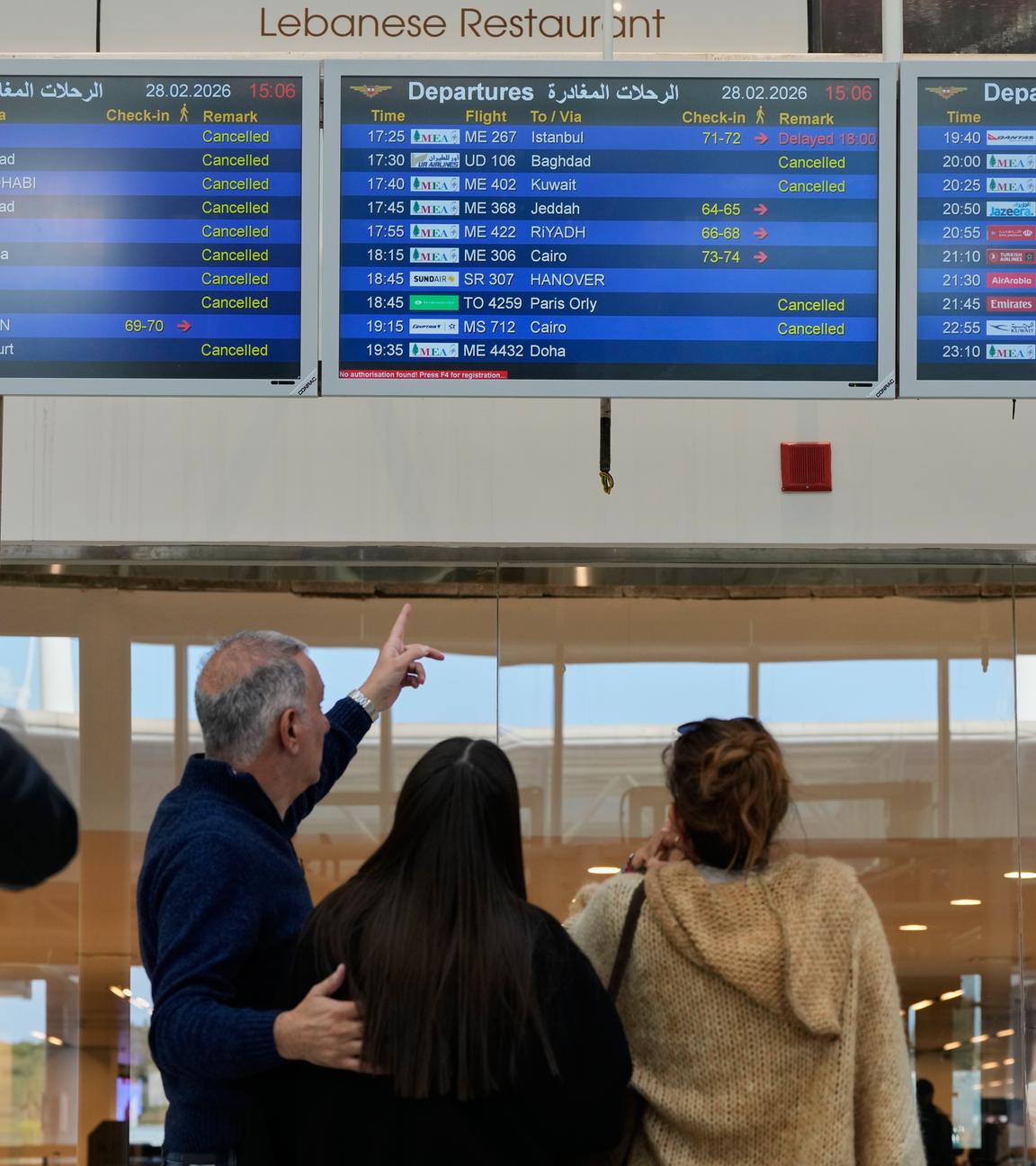 Reisende schauen auf die Anzeigetafel am FLughafen Beirut.
