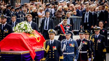 Beerdigung von König Harald von Norwegen in Oslo. Der Sarg mit einem roten durch wird von Männern in Uniform getragen.