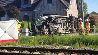 Rettungskräfte sind bei einem Unfallort im Einsatz, nachdem ein Zug mit einem Schulbus am Bahnübergang Vierhuizen in Buggenhout zusammengestoßen war, aufgenommen am 26.05.2026