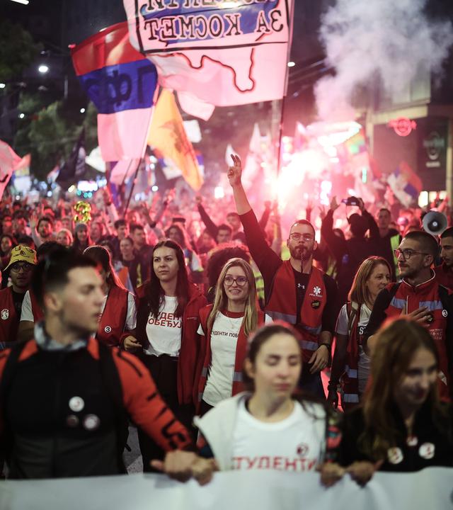 Menschen begrüßen eine Gruppe Studenten, die vor einer Wahlkampfveranstaltung mit dem Motto „Studentenliste – Studenten gewinnen“ in Belgrad, Serbien, eingetroffen sind.