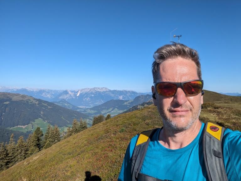 Ein Selfie von Benedikt Mayr beim Wandern in den Bergen.