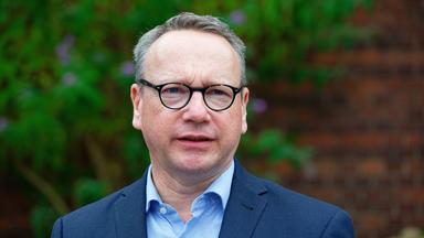 NRW-Justizminister Benjamin Limbach im Porträt. Er trägt einen dunkelblauen Anzug und ein hellblaues Hemd.