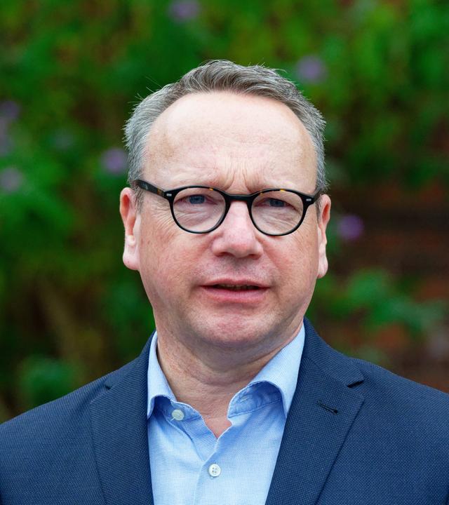 NRW-Justizminister Benjamin Limbach im Porträt. Er trägt einen dunkelblauen Anzug und ein hellblaues Hemd.