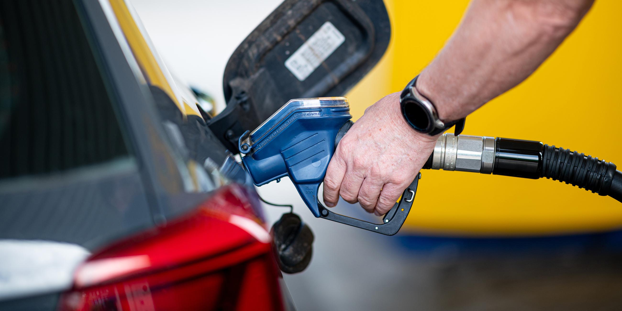 Ein Mann betankt an einer Tankstelle sein Auto
