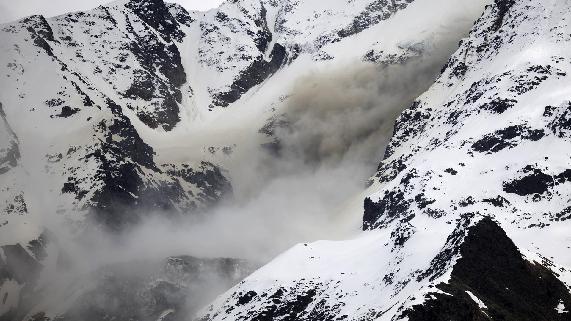 Dust from a rockfall rises on a flank of the Bietschhorn mountain in the Loetschental valley, taken from the village of Wiler,
