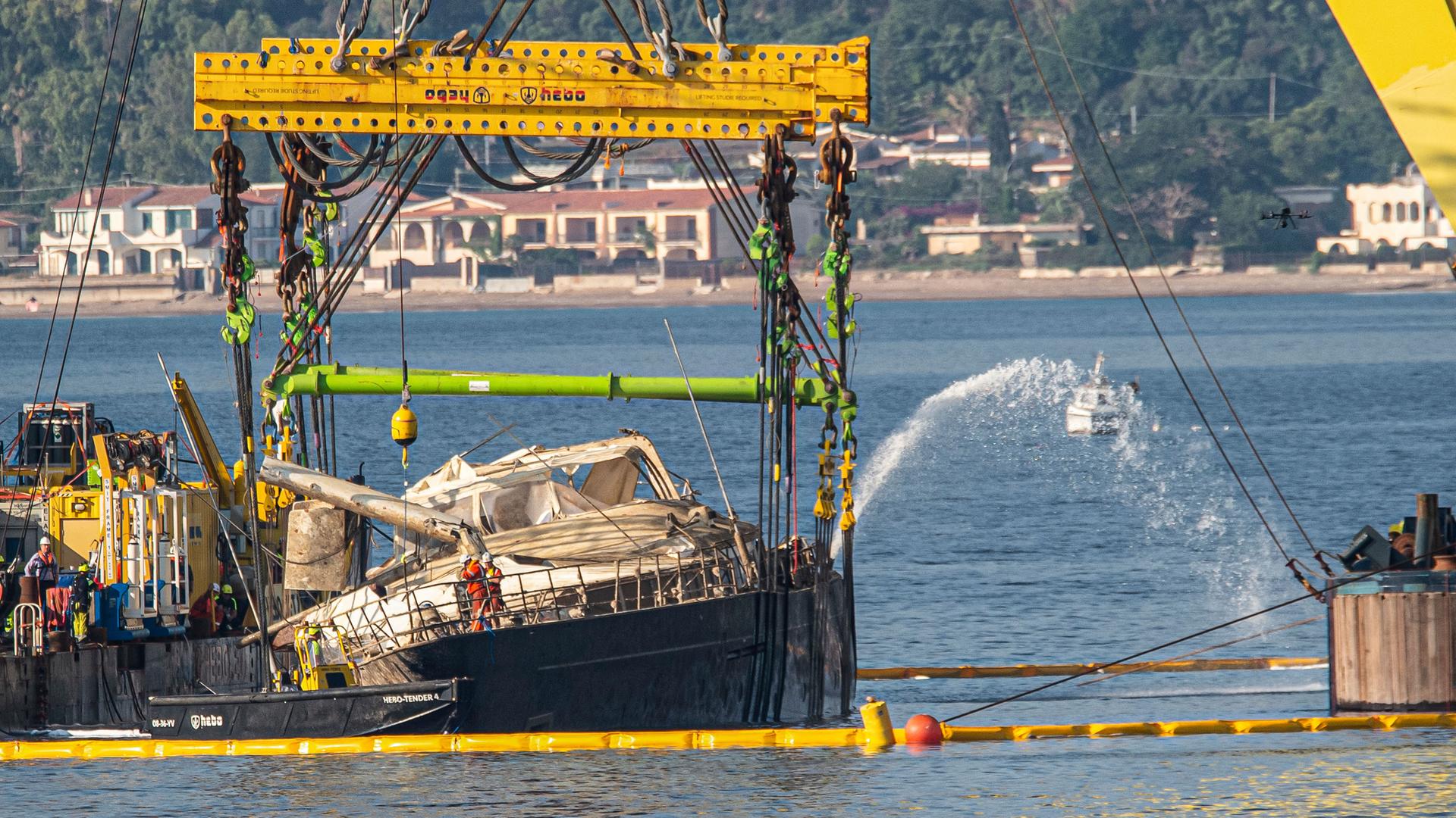 Der Rumpf der Superjacht "Bayesian", die am 19. August 2024 in der Nähe von Palermo, Sizilien, gesunken ist, wird am 21.06.2025, während der Bergungsarbeiten vor dem Dorf Porticello von Kränen angehoben.