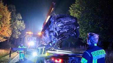 Ein Abschlepper hebt ein verbranntes Auto auf seinen Transporter. 