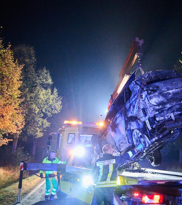 Ein Abschlepper hebt ein verbranntes Auto auf seinen Transporter. 