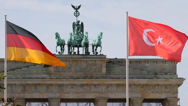 Die Deutsche und die Tuerkische Nationalflagge wehen vor dem Brandenburger Tor in Berlin