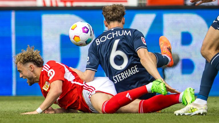 Berlins Benedict Hollerbach landet im Zweikampf mit Patrick Osterhage von VfL Bochum am Boden beim Spiel am 05.05.2024.