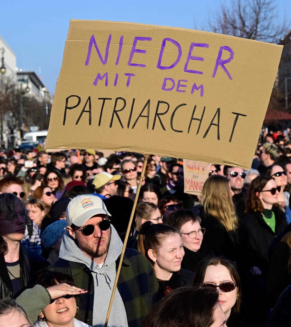 Demonstranten halten ein Plakat mit der Aufschrift „Nieder mit dem Patriarchat“ hoch.