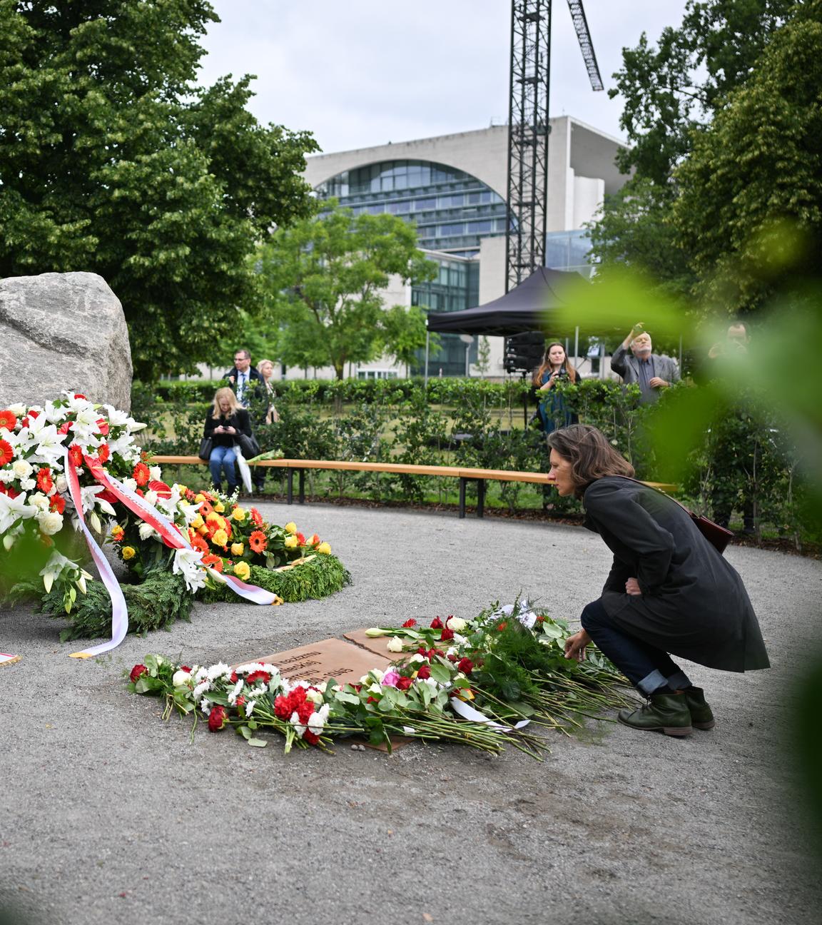  Eine Frau legt während der Übergabe eines temporären Denkmals zur Erinnerung an die polnischen Opfer des Zweiten Weltkriegs und der deutschen Gewaltherrschaft eine Blume ab.