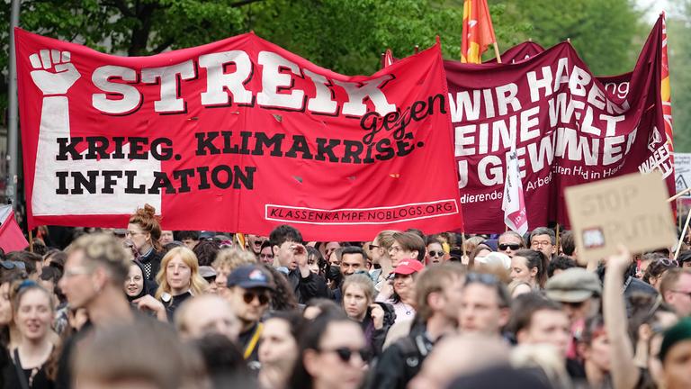  Berlin: Demonstranten halten ein Banner mit der Aufschrift "Streik gegen Krieg. Klimakrise. Inflation" hoch.