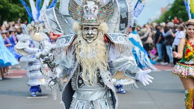 Verkleidete Menschen unterschiedlicher Kulturen tanzen zur Musik beim Straßenumzug zum 27. Karneval der Kulturen.