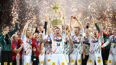 Magdeburgs Spieler jubeln mit der Trophäe nach dem Sieg gegen Berlin am 15.06.2025.