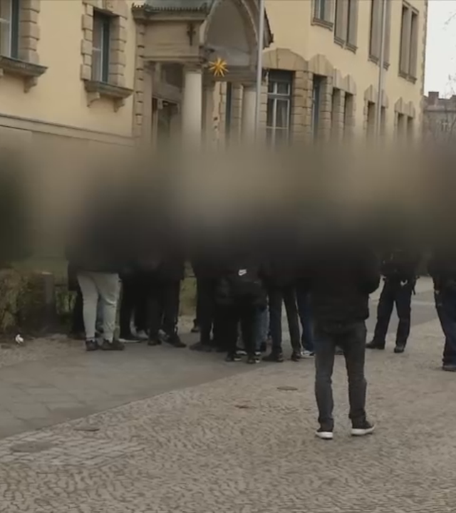 Bild von Schülerinnen und Schülern auf einem Schulhof, alle schwarz gekleidet. Die Identität der Abgebildeten wurde verfremdet.