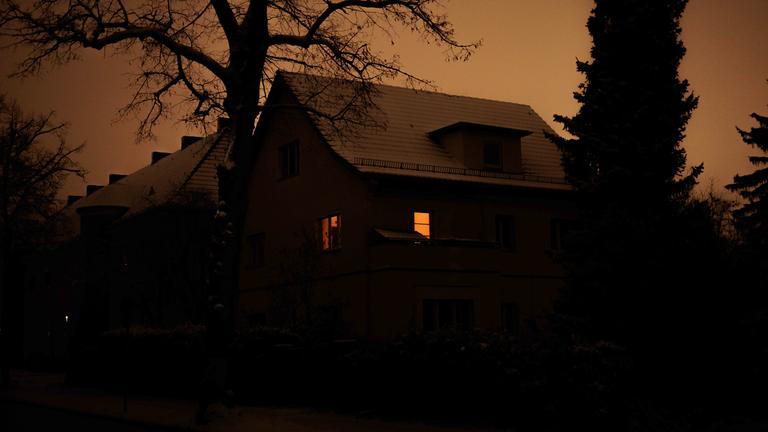 Ein Wohnhaus in Berlin ist nach dem Stromausfall mit Kerzen erleuchtet.
