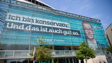 Das Wahlplakat mit dem Spitzenkandidaten der CDU, Evers, hängt hinter der Glasfassade des Konrad-Adenauer-Hauses.