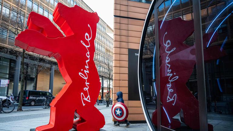 Ein roter Bär mit der Aufschrift "Berlinale" steht vor einem Einkaufszentrum.
