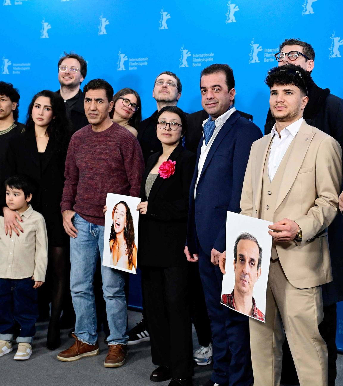 Gruppenbild der afghanischen Schauspieler des Films No Good Men auf der Berlinale, die Fotos von den Kollegen, die nicht dabei sein können, hochhalten.