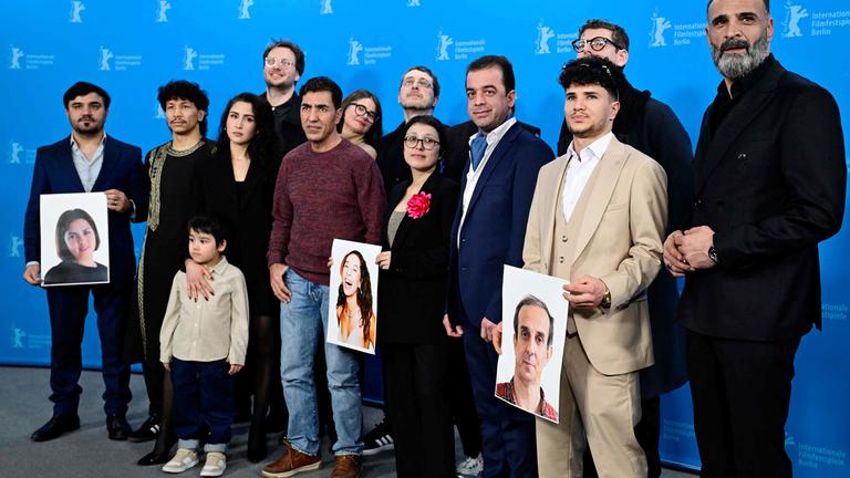 Gruppenbild der afghanischen Schauspieler des Films No Good Men auf der Berlinale, die Fotos von den Kollegen, die nicht dabei sein können, hochhalten.