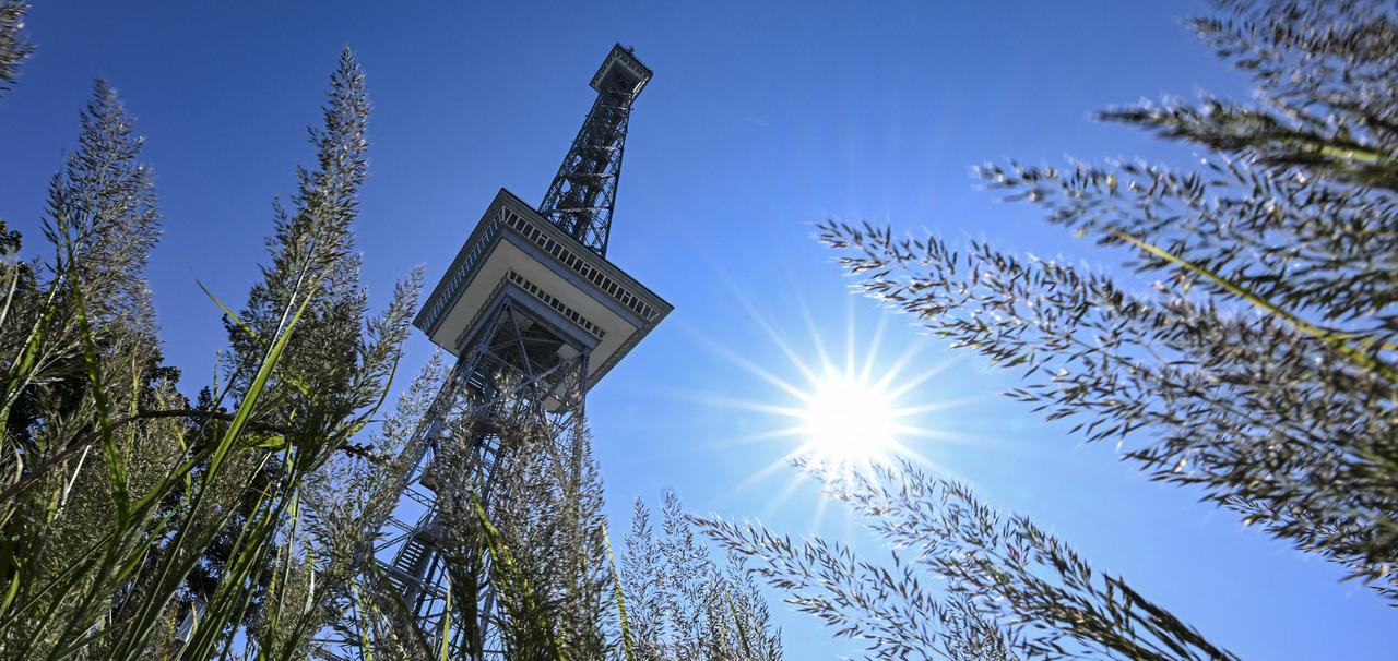 Der Berliner Funkturm steht vor strahlend blauem Himmel auf dem Messegelände.