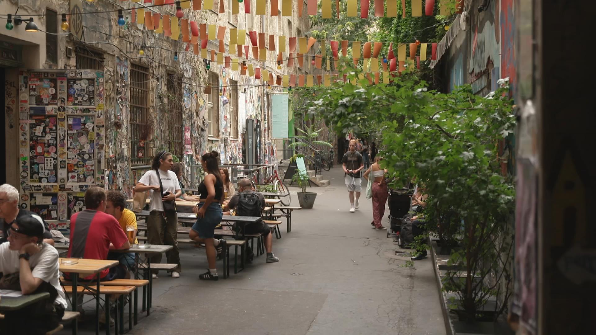 Leute an Tischen eines Cafés in Berliner Hinterhof