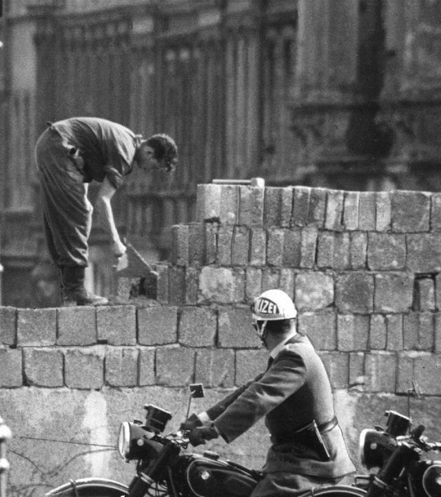 Bauarbeiter arbeiten an der Berliner Mauer.