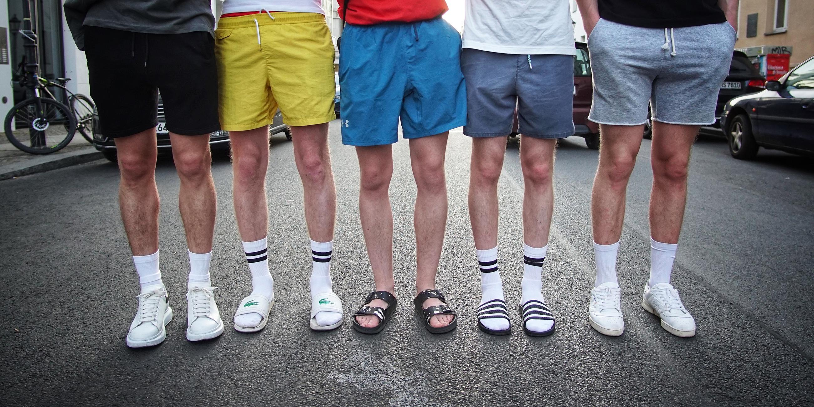 Männer tragen weiße Socken in Badelatschen und Sneakern