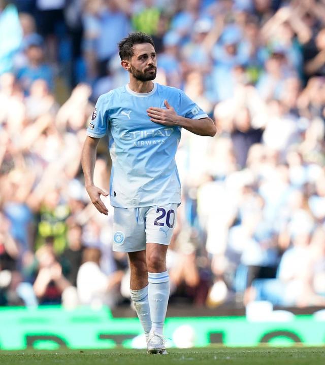Bernardo Silva, hier noch im hellblauen Heim-Dress von Manchester City klopft sich mit der linken Hand auf die Brust und schaut ins Publikum.