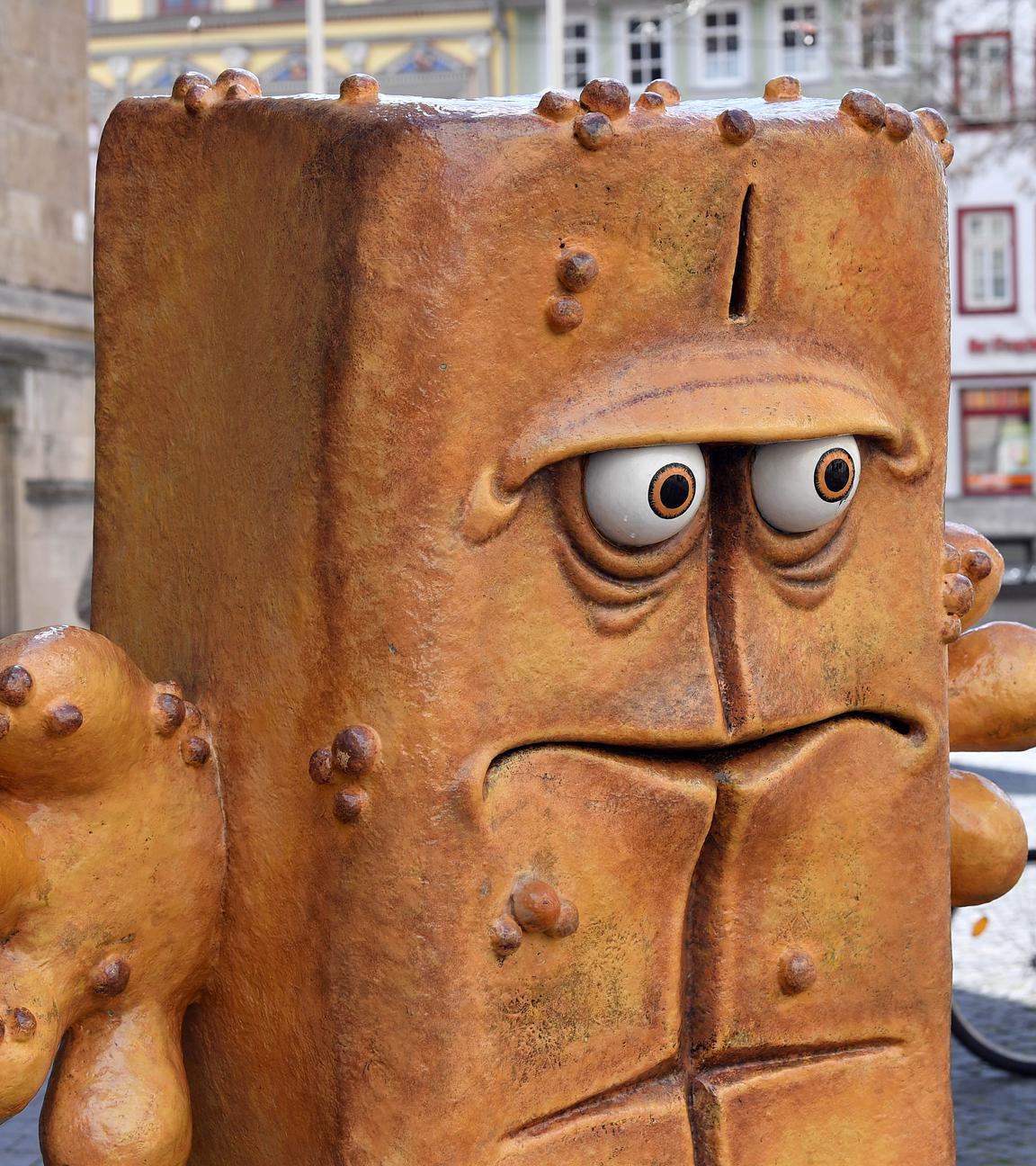 Passanten laufen hinter der Figur "Bernd das Brot" aus dem Kinderfernsehen neben dem Rathaus am Fischmarkt entlang.