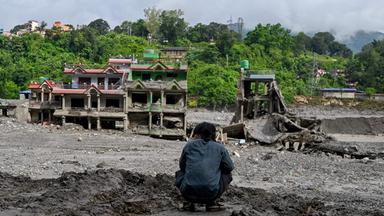 Ein Mann betrachtet am 31.08.2026 im Trishuli Center, im nepalesischen Distrikt Nuwakot, die durch Sturzfluten beschädigten Häuser. 
