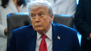 Donald Trump mit blauem Anzug und roter Krawatte