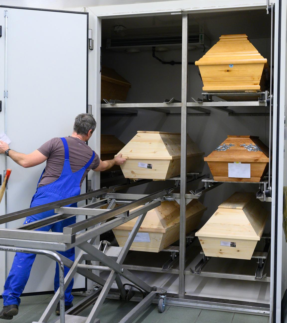 Swen Eichler, Feuerbestatter, zieht im Kühlraum im Krematorium Görlitz einen Sarg aus einem Regal.