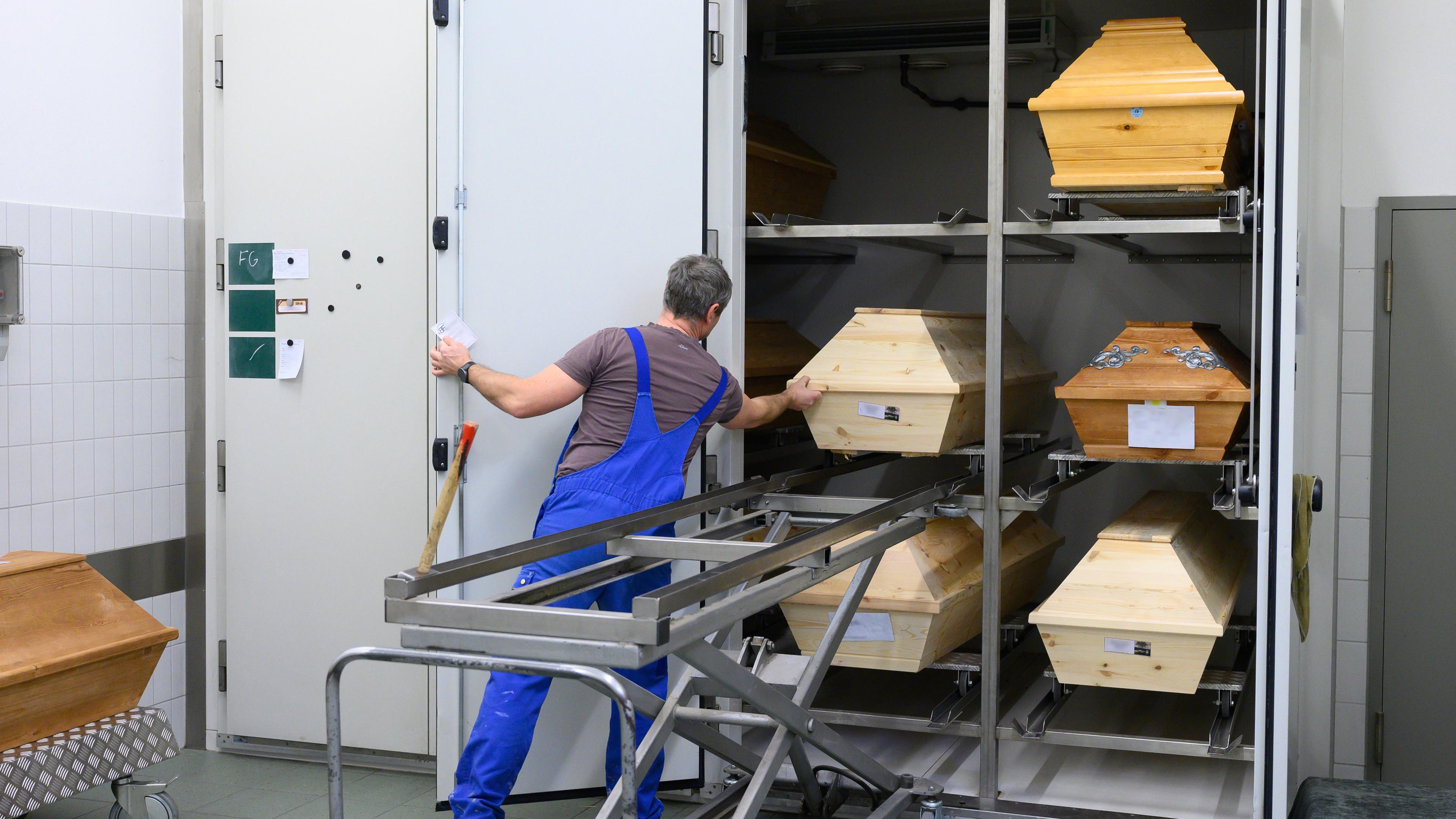 Swen Eichler, Feuerbestatter, zieht im Kühlraum im Krematorium Görlitz einen Sarg aus einem Regal.