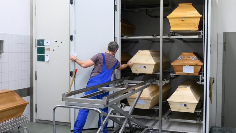 Swen Eichler, Feuerbestatter, zieht im Kühlraum im Krematorium Görlitz einen Sarg aus einem Regal.