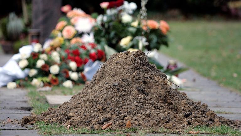 erdhaufen vor einem ausgehobenen grab