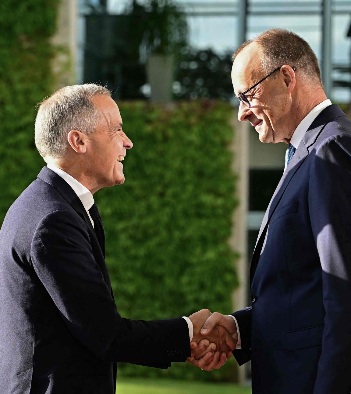 Bundeskanzler Merz und kanadischer Premierminister Mark Carney schütteln sich die Hände in die Berlin.