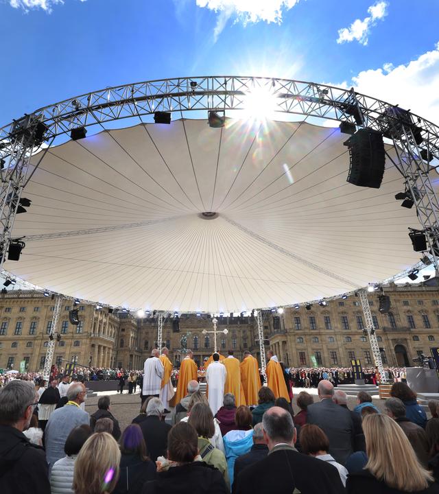 Besucher stehen auf dem Residenzplatz beim Abschlussgottesdienst des Katholikentags in Würzburg.
