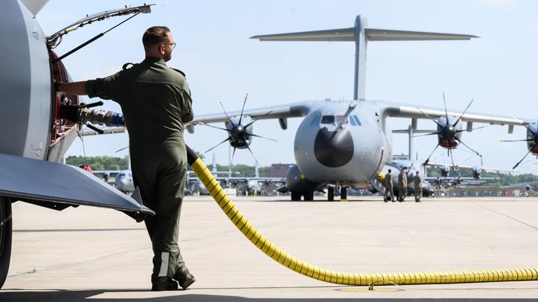 Ein Soldat betankt ein Flugzeug neben einem Airbus A400M der Luftwaffe der Bundeswehr. (Archiv)