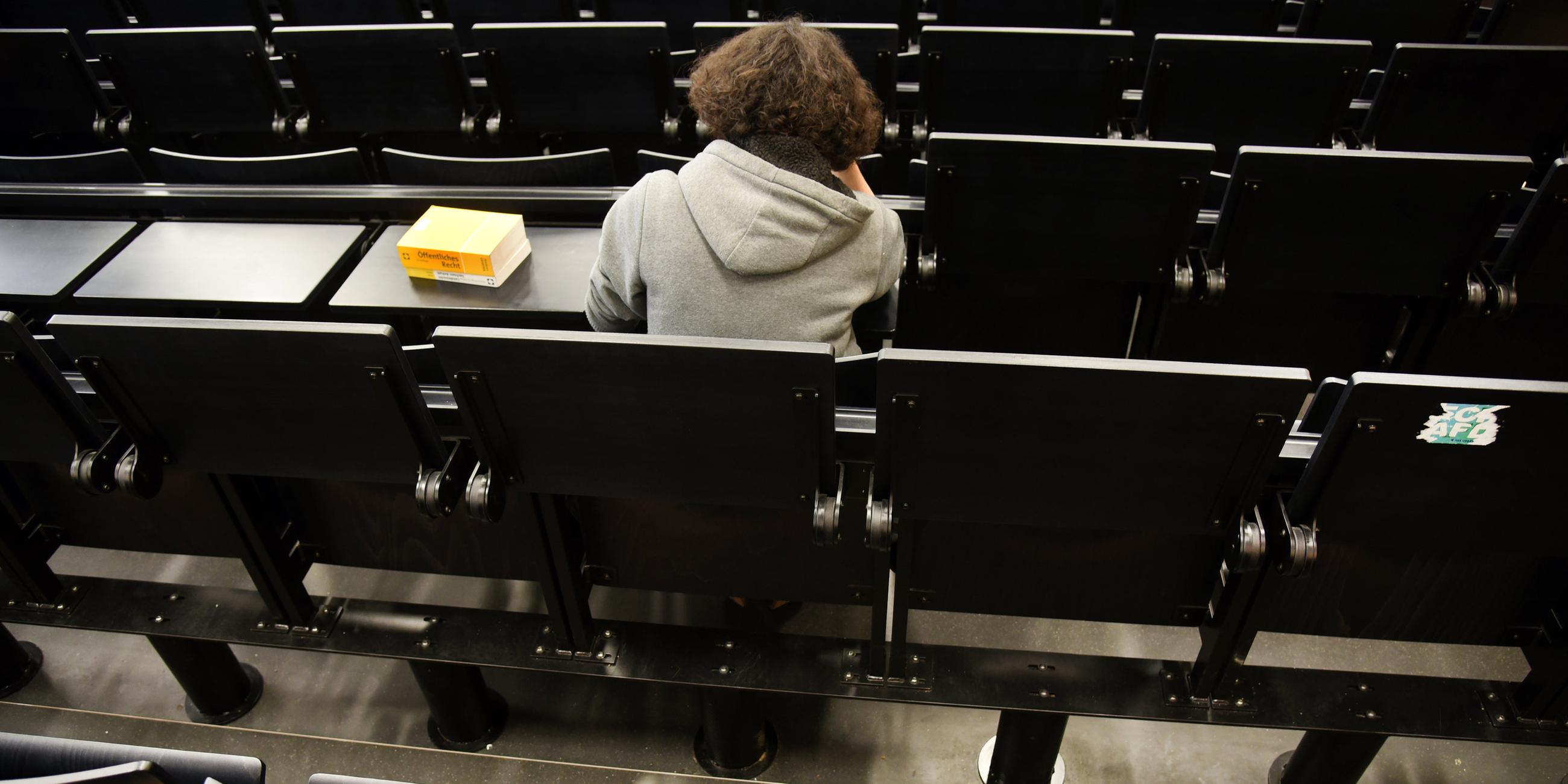 Eine einsame Studentin alleine in einem Hörsaal