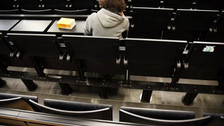 Eine einsame Studentin alleine in einem Hörsaal