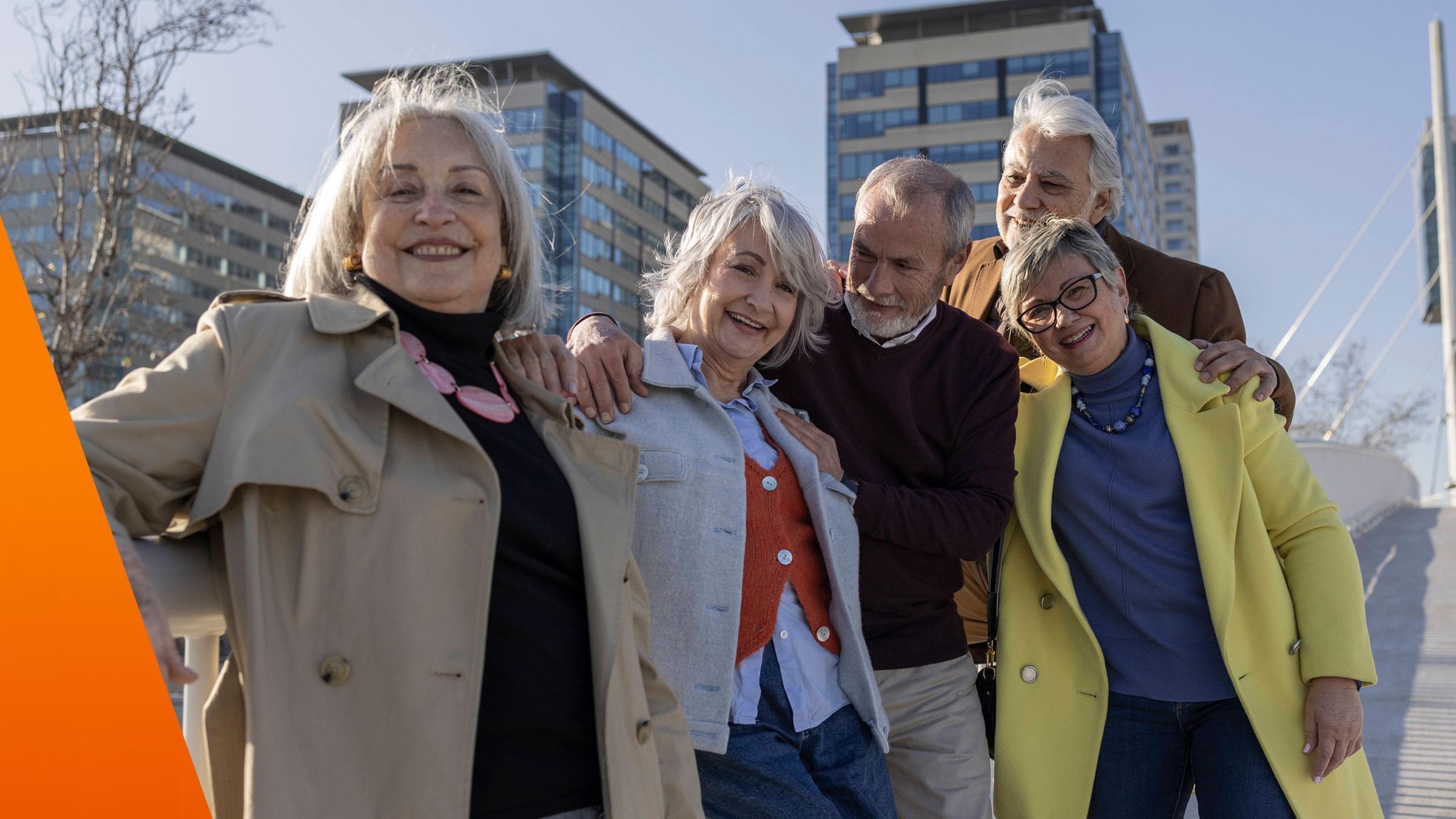 Ältere Menschen stehen an einer Brücke zusammen und lachen