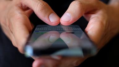 Smartphone in zwei Händen mit WhatsApp offen