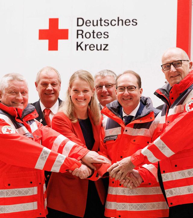 Christian Reuter (vorne, l-r), Generalsekretär des Deutschen Roten Kreuzes (DRK), Hermann Gröhe, DRK-Präsident, Sonja Eichwede (SPD), Bundestagsabgeordnete, Alexander Dobrindt (CSU), Bundesinnenminister, und Dietmar Woidke (SPD), Ministerpräsident von Brandenburg, stehen vor einem Container bei der Eröffnung des DRK-Bevölkerungsschutz-Hubs im Landkreis Teltow-Fläming. Es handelt sich nach Angaben des DRK um das größte und modernste Bevölkerungsschutzzentrum Deutschlands. Es soll für die nationale Krisenvorsorge eine Schlüsselrolle einnehmen, durch Lagerung und schnelle Bereitstellung von Hilfsgütern für Katastrophen in Deutschland.