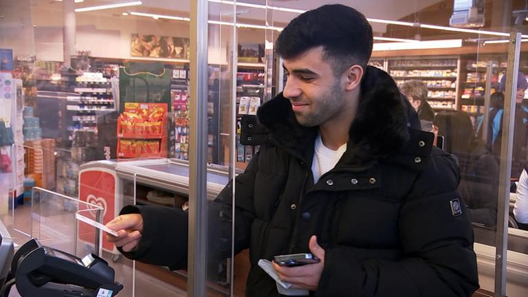 Mann bezahlt im Supermarkt mit einer Bezahlkarte