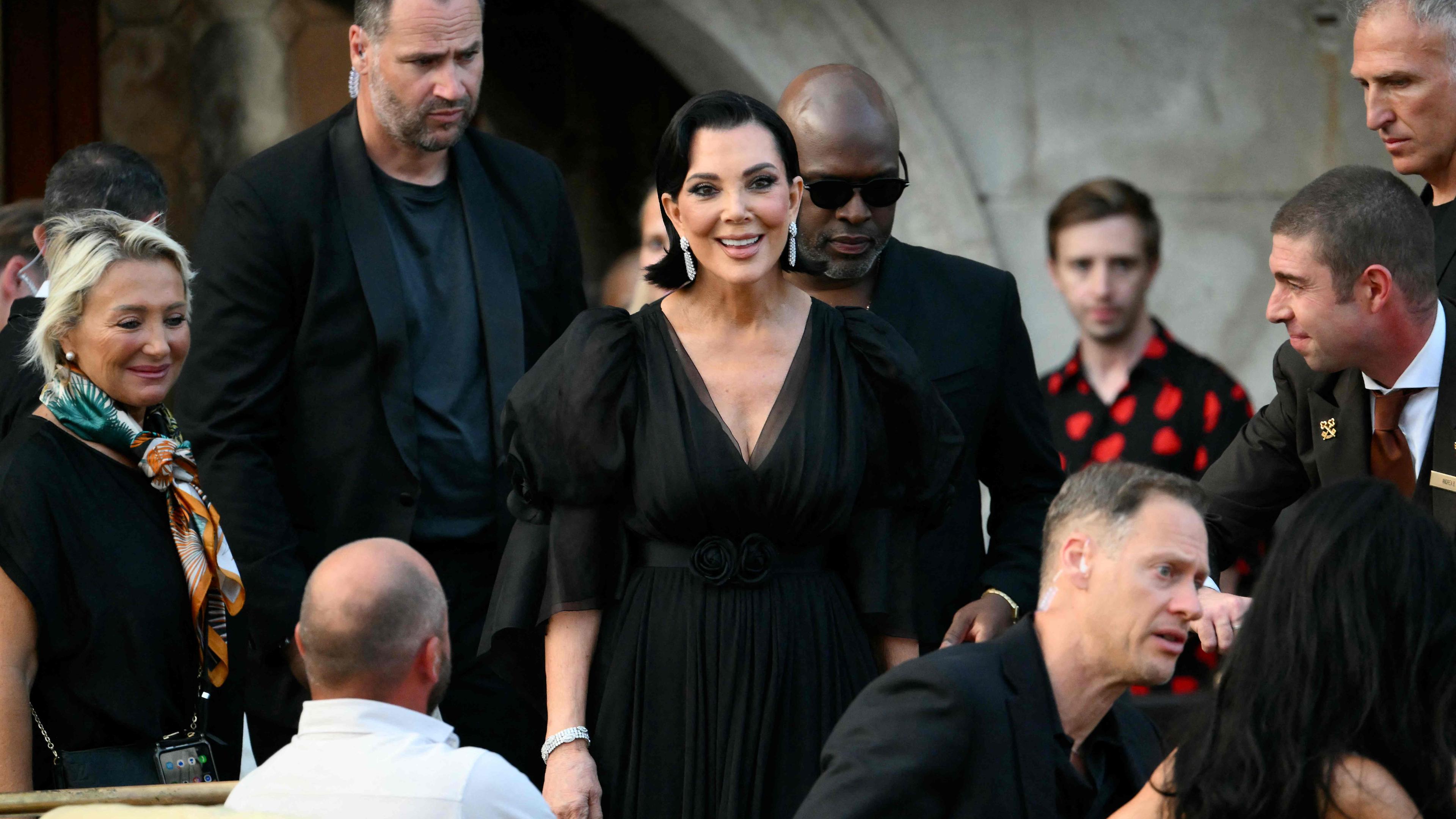 Kris Jenner inmitten von Bodyguards.